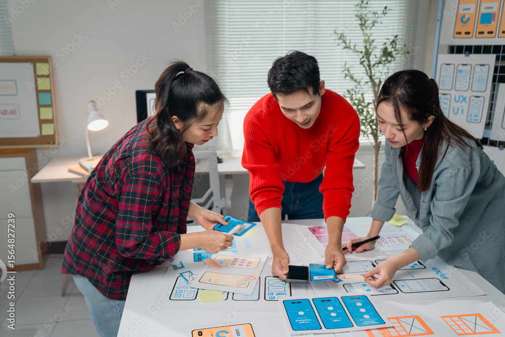 Poster diverse team of creative professionals collaborating on a mobile app design project, using wireframe