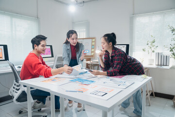 Three ui ux designers are working together on a mobile app interface wireframe design in a modern...