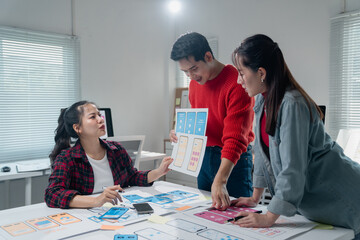 Group of young professionals engaged in a collaborative brainstorming session for mobile app...