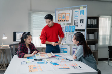 Creative team actively discussing and developing a mobile app design. Diverse group engaged in...