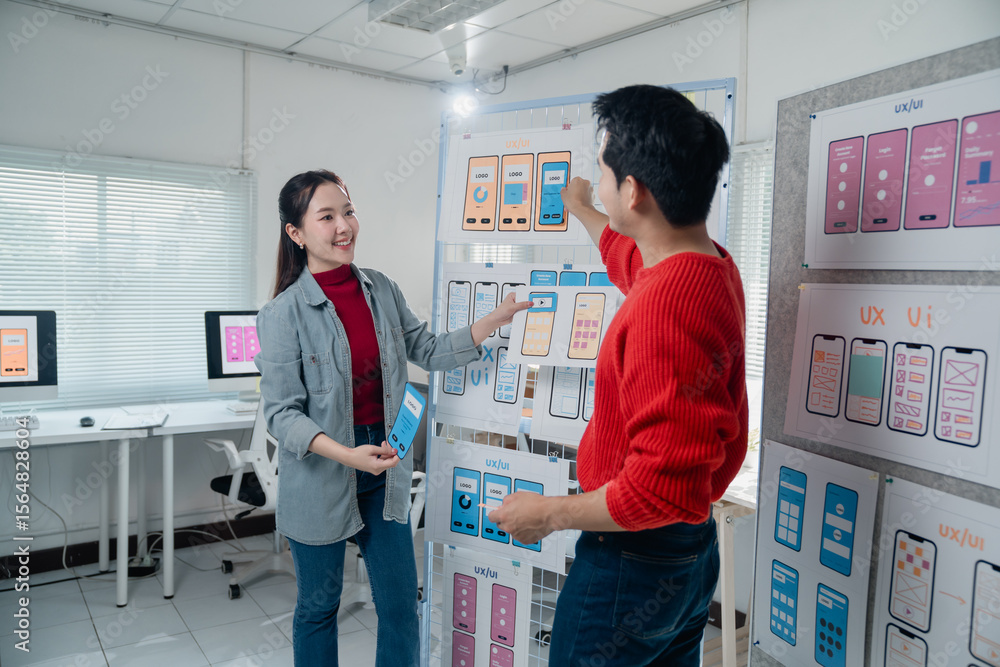 Poster two designers actively engaging in a ux design session, discussing and analyzing mobile app interfac