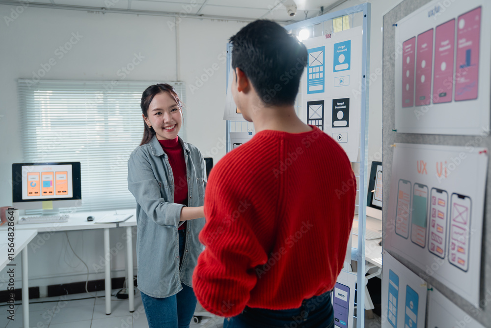Poster two asian web designers shaking hands after designing user interface for mobile application in moder
