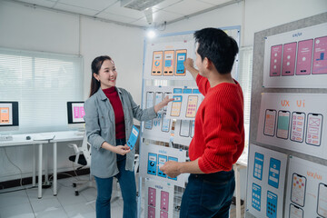 Two designers actively engaging in a UX design session, discussing and analyzing mobile app...