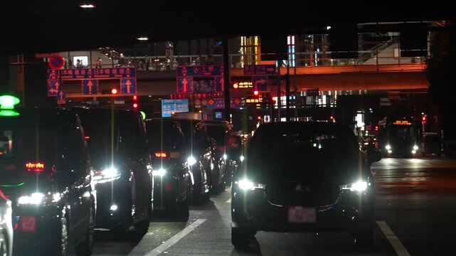 A clear Tokyo night, downtown cars shuttle as a train zips over the bridge. Neon lights tangle with buildings, tracing the city's late-night return scene.