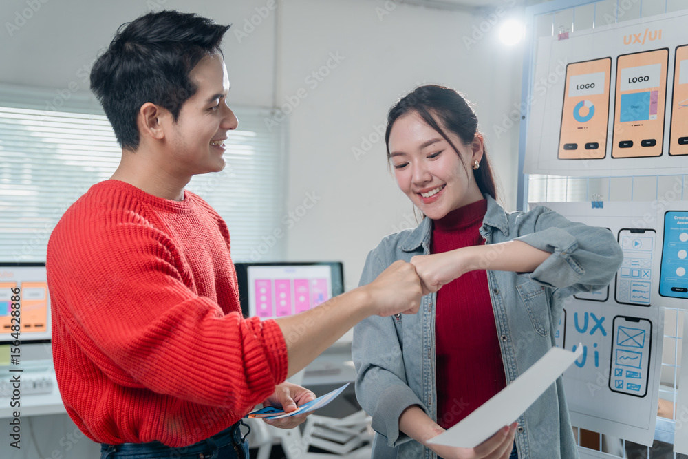 Aufkleber two young ux/ui designers are fist bumping to celebrate the successful completion of a project, show