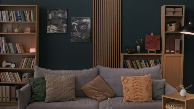 Zoom out no people shot of modern therapy office interior with comfortable sofa, small table and bookshelves on background providing relaxed setting for sessions