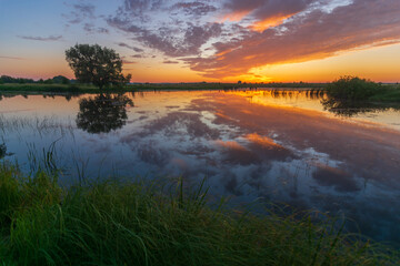 awesome summer sunrise over the lake and meadows