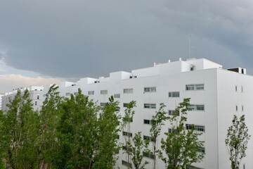 Dark clouds gather over contemporary white apartment buildings