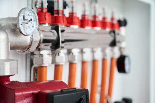 Close-up view of a heating system featuring valves, gauges, and colorful pipes for efficient home heating.