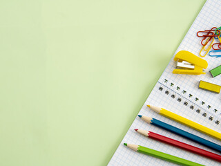 The Back to school concept with school supplies on a green background, free space for copying in a...