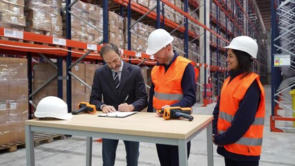 Business manager signing a contract and shaking hands with warehouse workers, finalizing a successful agreement