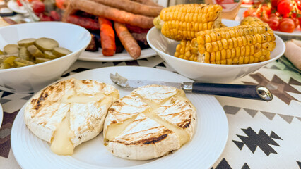 Grilled camembert oozing with molten charm, nestled amidst summer cornucopia, ideal for Bastille...
