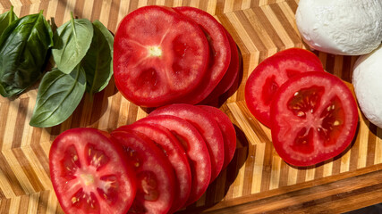 Sunlit tomato slices dance with fresh basil leaves and mozzarella orbs, evoking Caprese dreams and Harvest Moon feasts