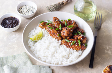 Chicken wings in teriyaki sauce with rice, sesame and onion. Asian food.