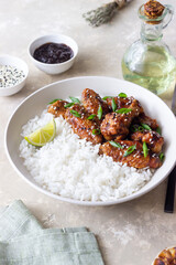 Chicken wings in teriyaki sauce with rice, sesame and onion. Asian food.