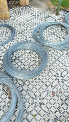 Circular steel coils rest on intricately geometric pavement, whispering tales of industrial...