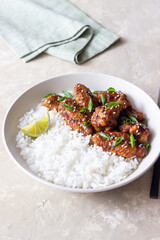 Chicken wings in teriyaki sauce with rice, sesame and onion. Asian food.