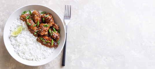 Chicken wings in teriyaki sauce with rice, sesame and onion. Asian food.