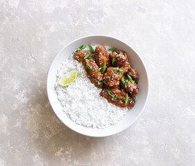 Chicken wings in teriyaki sauce with rice, sesame and onion. Asian food.