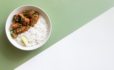 Chicken wings in teriyaki sauce with rice, sesame and onion. Asian food.