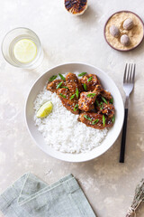 Chicken wings in teriyaki sauce with rice, sesame and onion. Asian food.