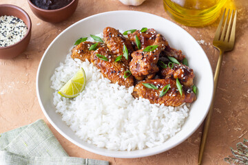 Chicken wings in teriyaki sauce with rice, sesame and onion. Asian food.