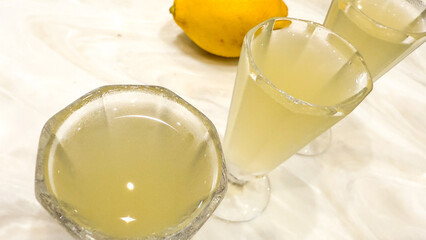 Zesty limoncello splashes in crystalline goblets, invoking Italian summer solstice and citrus-laden Amalfi Coast celebrations