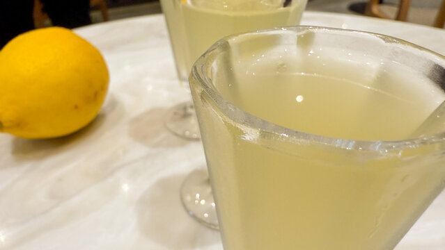 Chilled lemony elixirs shimmer beside sunlit citrus, evoking zestful beginnings, Mediterranean solstice soirees, and tangy culinary alchemy