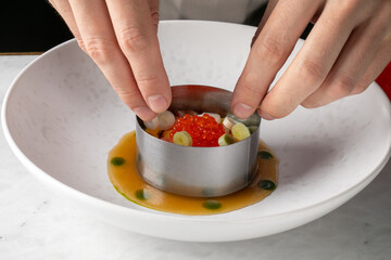 Sculpting culinary artistry, hands craft avant-garde salmon tartare, echoing Hanami delights and...