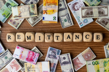 The word "REMITTANCE" surrounded by a banknotes from various countries. Remittances, global money transfers, international finance, and cross-border payments concept.
