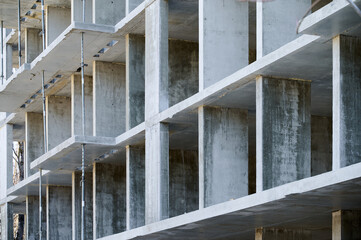 Freshly constructed concrete framework displays columns and beams at a construction site during daylight.