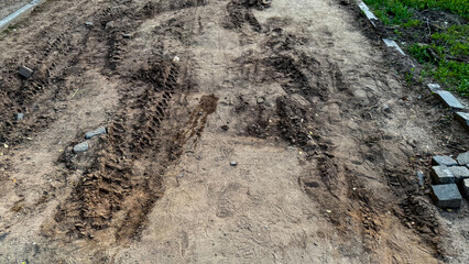 Uneven tire tracks woven into an earthy tapestry, hinting at intriguing journeys, rural tech adventures, and Tractor Day