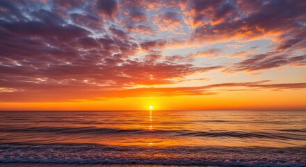 Obraz premium Vibrant sunset over a calm ocean shoreline.