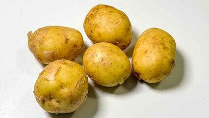 Golden tubers glisten under bright light, symbolizing earthy abundance for Potato Appreciation Day and quirky kitchen witchcraft rituals