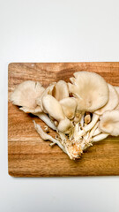 Oyster mushrooms bloom like forest whispers on rustic wood, perfect for a mycological feast or...