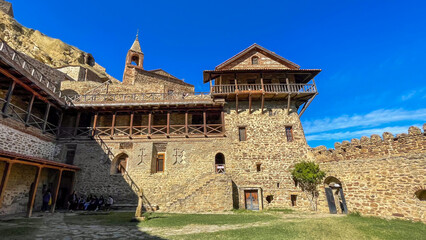 Ancient stone fortress basking under cerulean skies whispers tales of medieval trade; celebrate...