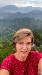 A Caucasian woman smiles amid misty mountains, evoking Wanderlust Day and ancient pagoda...