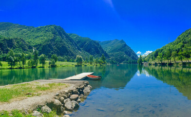 Serene emerald lake cradled by verdant mountains, ideal for Meditative Solstice or Alpine...