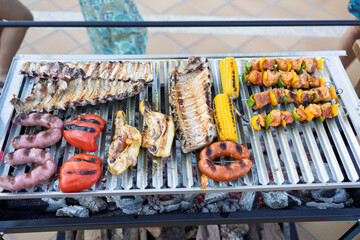 Grilling assorted meats and vegetables for summer barbecue party