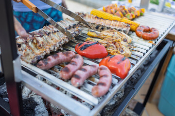 Variety of meat and vegetables grilling on a barbecue grill during summer party