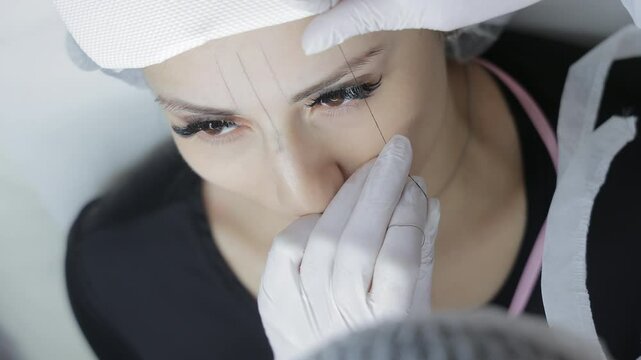 Cosmetic Procedure Preparation Scene, Beautician Drawing Guidelines on Woman's Face with Thread