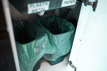 Sorting trash bins at home. Household waste sorting in the kitchen cabinet.