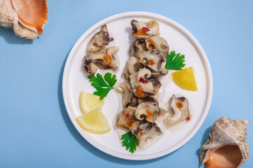 Pickled rapan meat with oil, spices and greens. Healthy seafood rich of omega