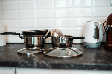 Pots and other kitchenware on a kitchentop. Clean kitchen concept.