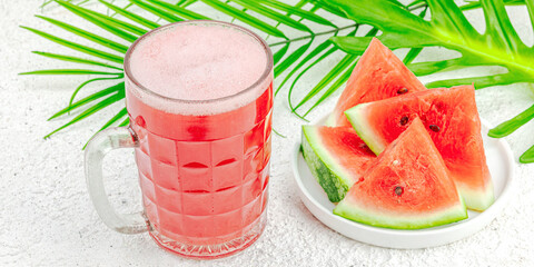 Trendy watermelon beer. Traditional Oktoberfest drink, kvass with palm leaves. Modern beverage