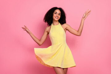Charming young woman in yellow dress on pink background exuding happiness and glamour, ideal for...