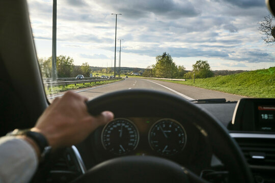 A person driving on a scenic, open road with a clear sky and lush greenery. Black Forest, Germany
