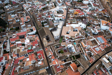 An aerial view captures the historic ancient city of Cordoba spanning the Guadalquivir River at sunrise, with the city's ancient architecture bathed in golden light