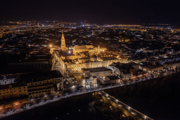 An aerial view showcases the stunning Mosque-Cathedral of Cordoba, with its distinctive bell tower...