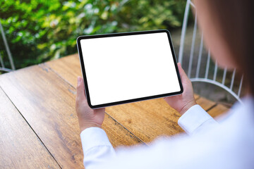 Mockup image of a woman holding digital tablet with blank white desktop screen in the outdoors
